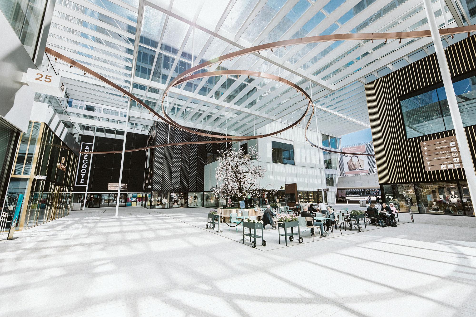 Dining area in a mixed-use development, surrounded by shops